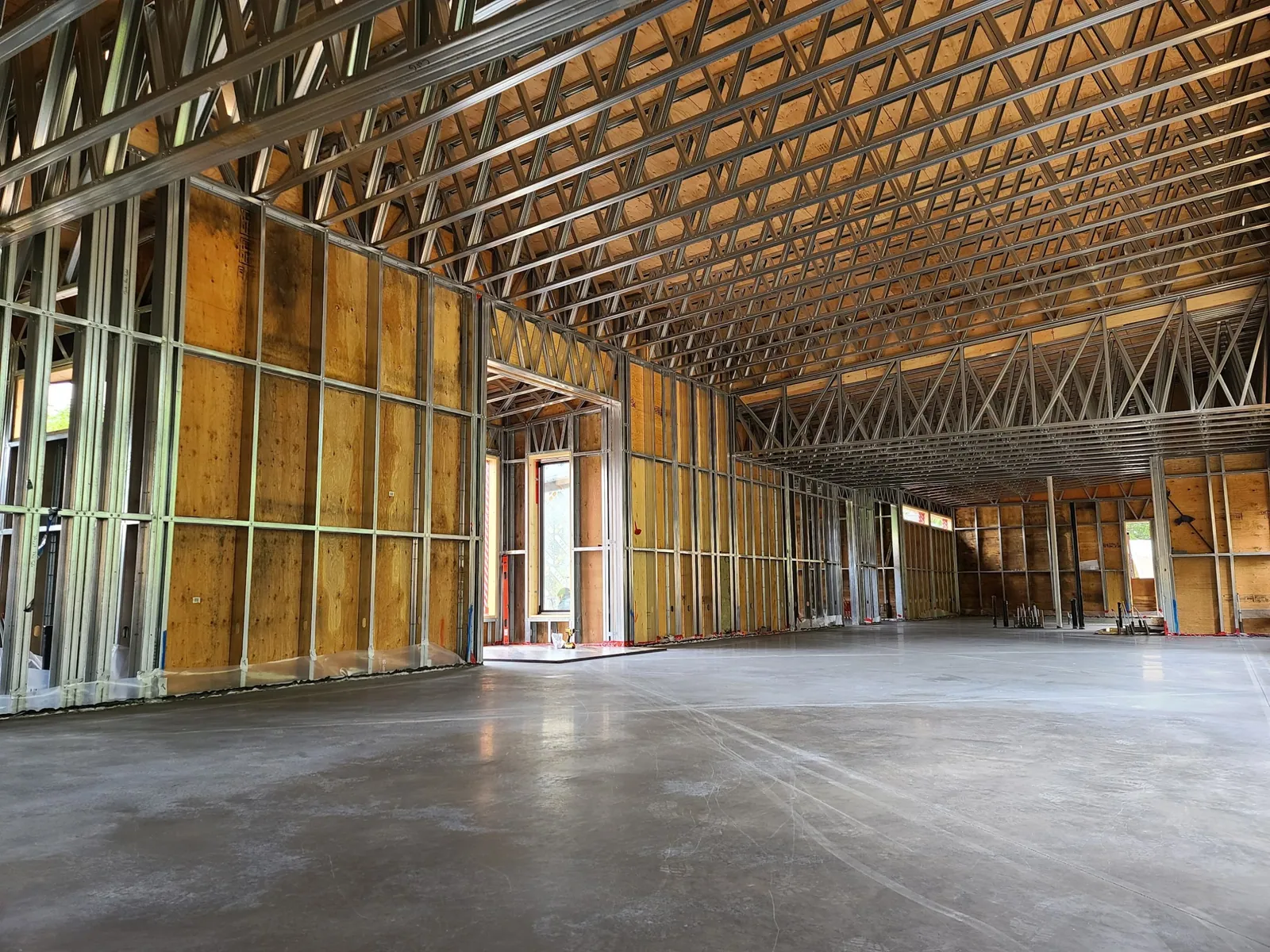 Interior of a large building framed with light-gauge steel walls and long-span roof trusses