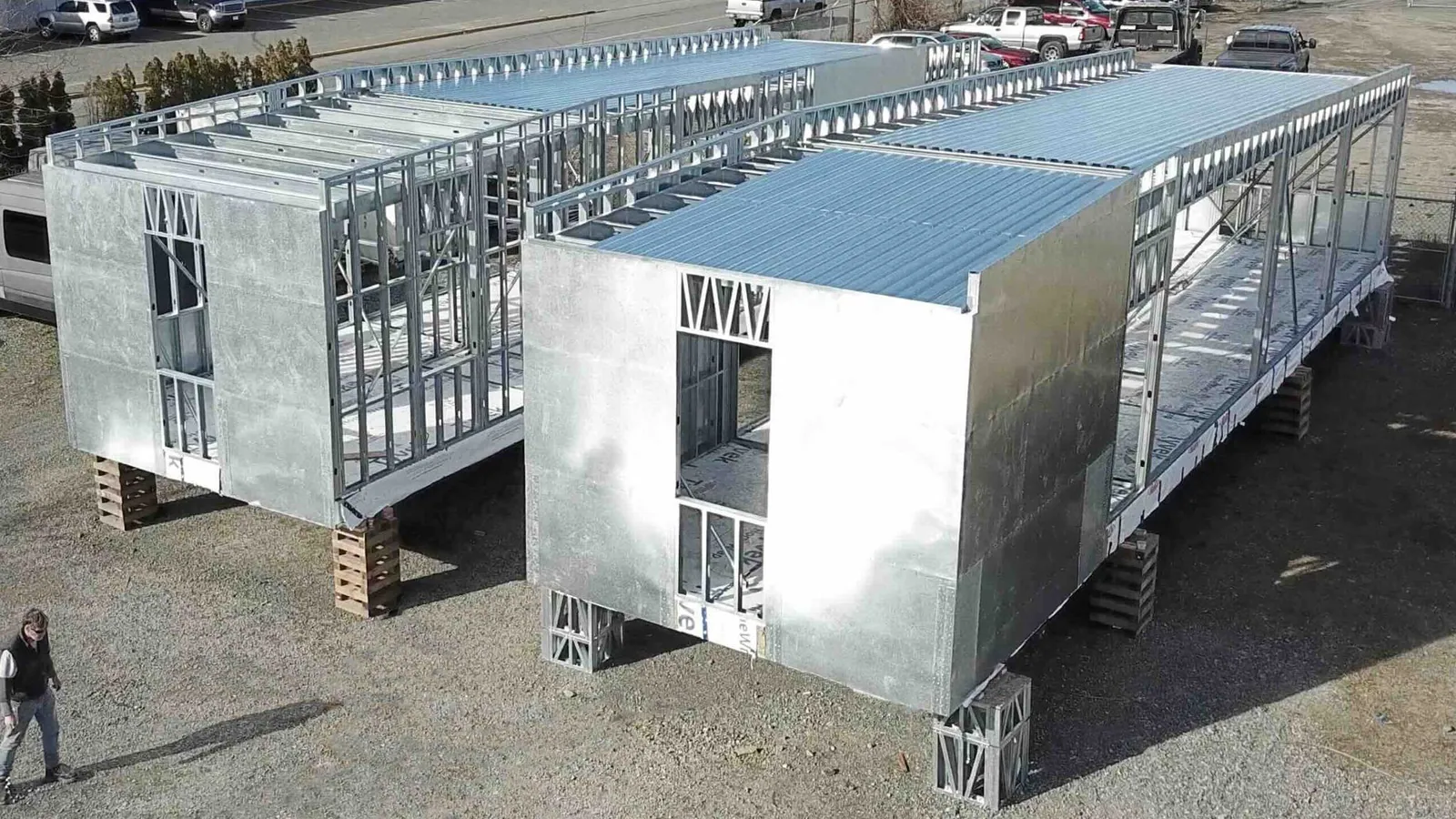 Two light-gauge steel module frames with sheathed walls and steel roof decking, set on steel blocking