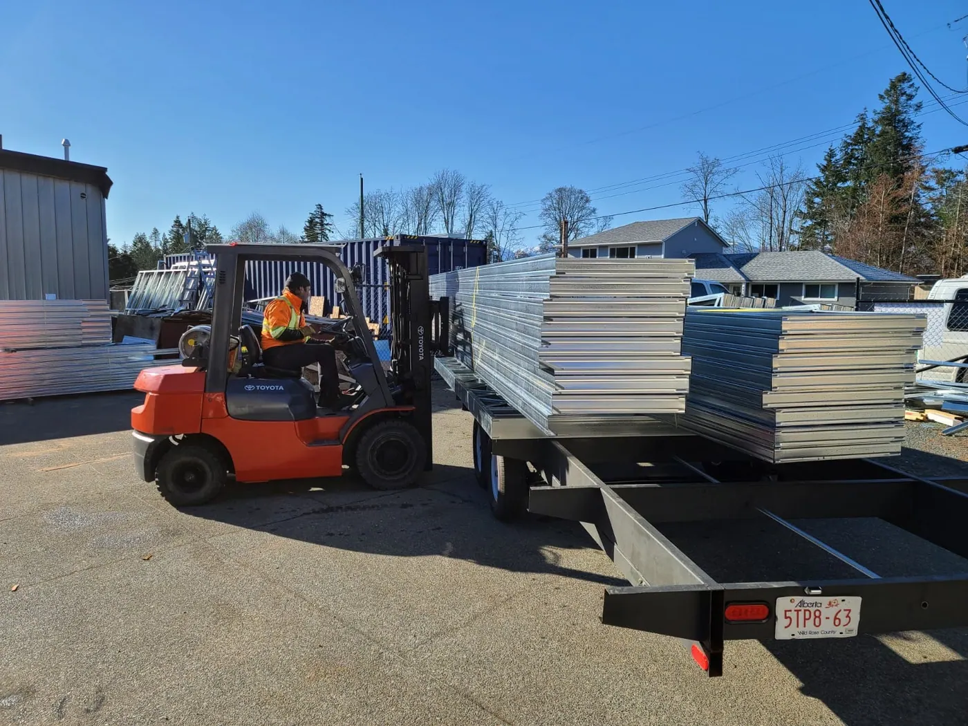 Forklift loading steel panels onto a trailer