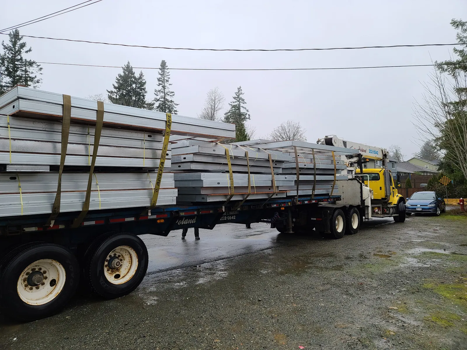 Prefabricated steel wall panels stacked on a flatbed trailer