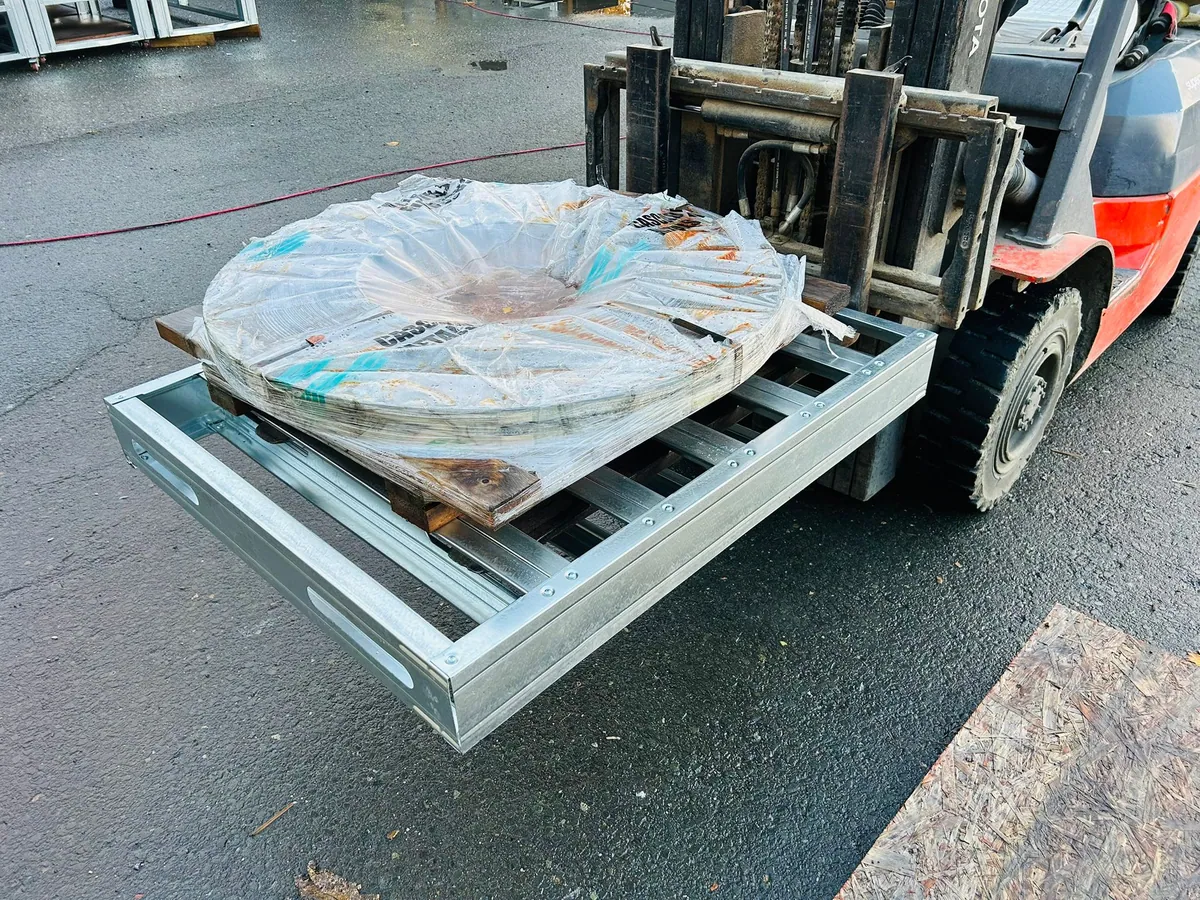 Closed-deck steel pallet carrying a wrapped coil on a forklift